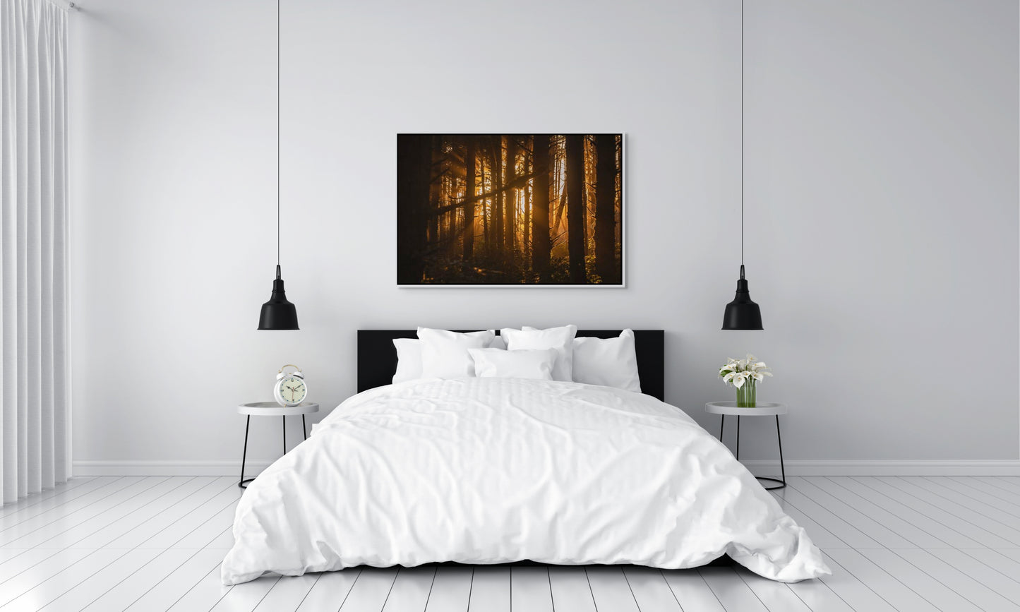 Bedroom with a forest painting above the bed of sunlight filtering through trees at sunset in the forest at Long Beach, Tofino, BC. White float frame.