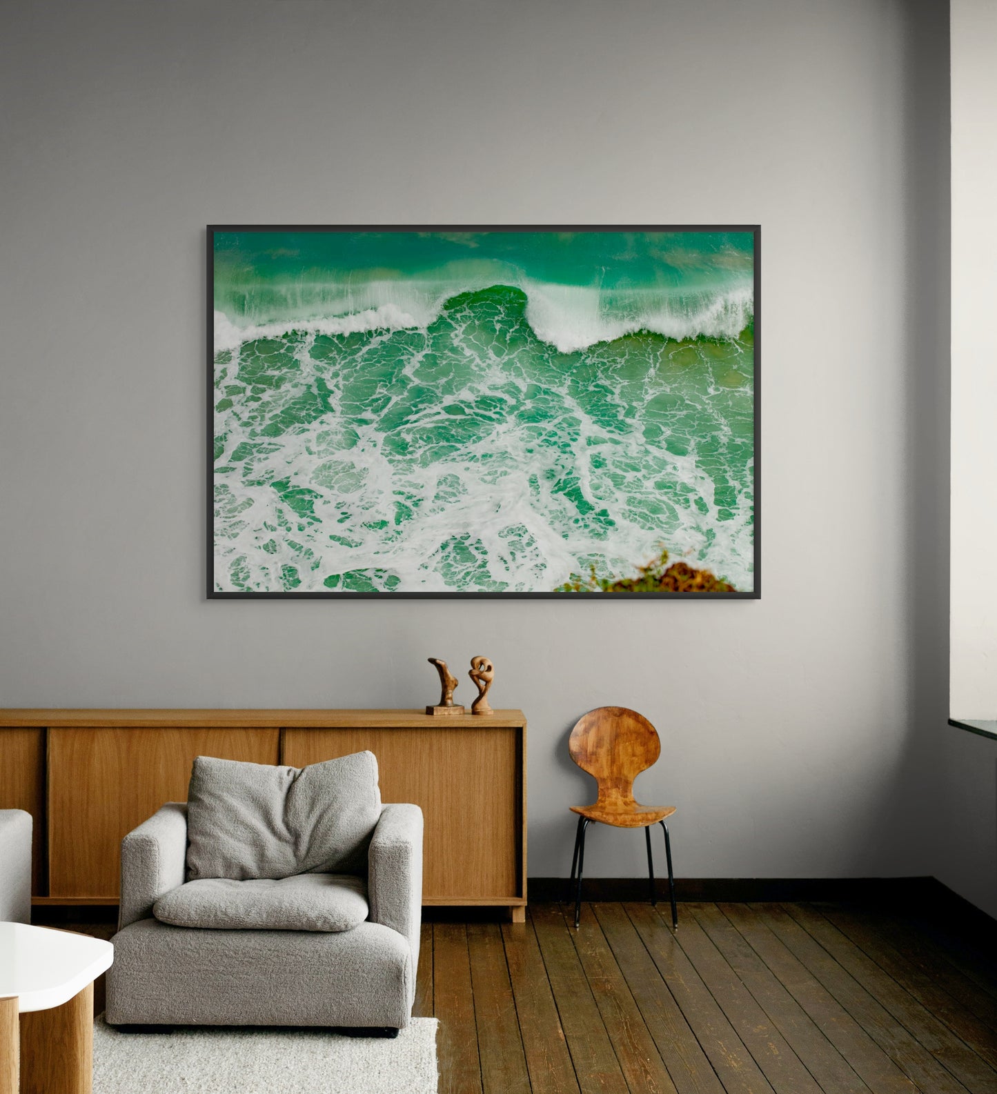 Black framed artwork of ocean waves in a modern living room.