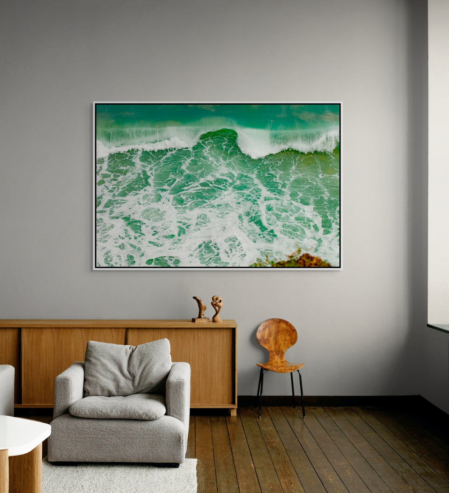 White framed artwork of a wave on a wall in a modern living room.