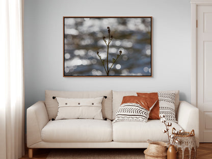 Beige sofa with decorative pillows and a framed artwork depicting a bracken fern sprouting its fronds in spring on the wall. Cedar float frame.